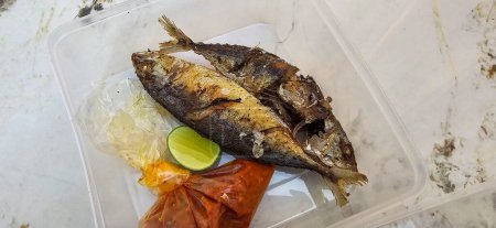 Gebratene Makrele serviert mit separater Chilisoße und Limette, oder Ikan kembung goreng genannt. ikan banyar goreng mit rica sambal in indonesischer Sprache, Fried Rastrelliger sp. Fischproteinquelle, die billig ist. Perfekt für Rezept, Artikel oder jeden Koch
