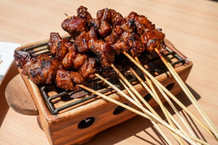 Homemade lamb or mutton satay marinated with spice and sweet soy sauce, coriander goat satay, served with chilli, soy sauce and tomato. Indonesian traditional satay recipe for grilled meat