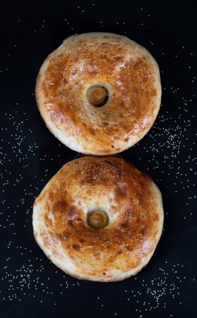 Téléchargez les photos : Deux pains en forme de huit sur fond noir. Nourriture nationale ouzbèke. Concept du 8 mars - en image libre de droit