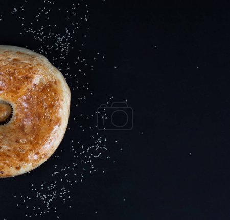 Téléchargez les photos : La moitié du pain rond sur fond noir. Nourriture nationale ouzbèke - en image libre de droit