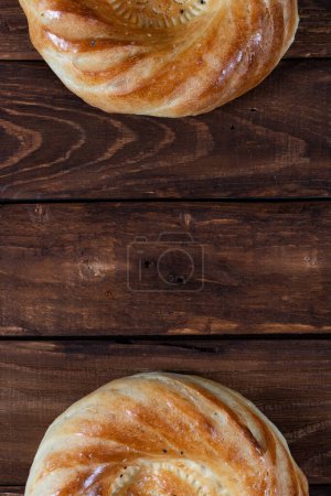 Téléchargez les photos : La moitié de deux pain de voyage ouzbek gâteau sur fond en bois. Endroit pour le texte. Carte postale vacances - en image libre de droit