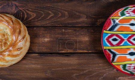 Téléchargez les photos : Rishtan Assiette nationale ouzbèke et pain gâteau voyage sur fond en bois. Carte postale pour Navruz, Kurban bayram - en image libre de droit