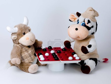 Téléchargez les photos : Soft toys cow and bull and board logic game "Pentago" - en image libre de droit