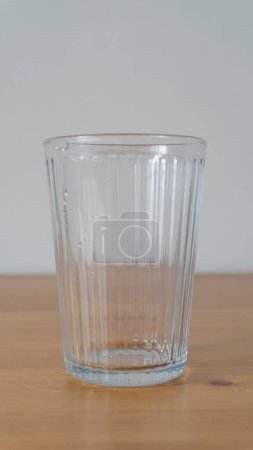 Clear glass, ribbed texture, wooden backdrop