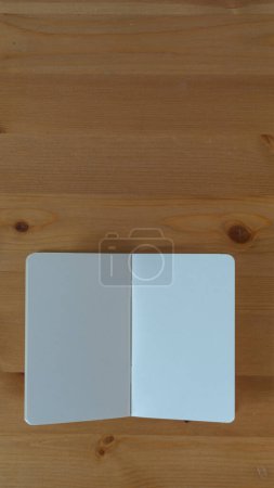 Foto de Cuaderno en blanco invitando inspiración, telón de fondo de madera - Imagen libre de derechos