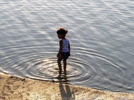 Téléchargez les photos : Maumere, Flores, Indonésie- 23 mai 2023 : un enfant joue dans l'eau sur la plage - en image libre de droit