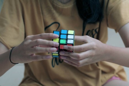 Foto de Yakarta, Indonesia - 01 de julio de 2023: Acercamiento de la mano femenina sosteniendo un cubo de Rubik. - Imagen libre de derechos