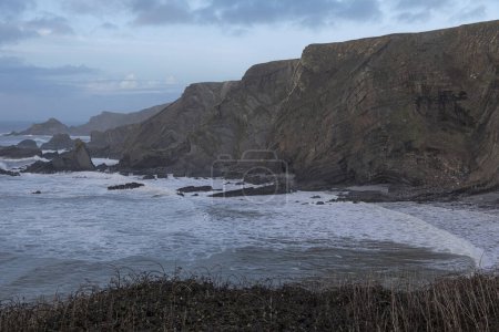 Foto de Mirando hacia fuera para ver en una costa escarpada en la costa sur con un mar tormentoso - Imagen libre de derechos