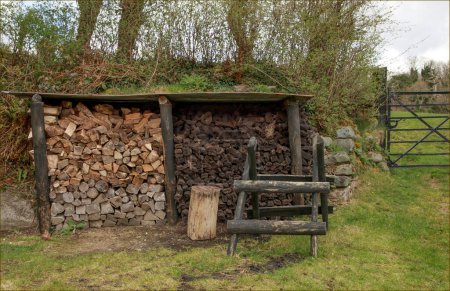 Piles of wood and peat ready for Winter under a wooden shelter