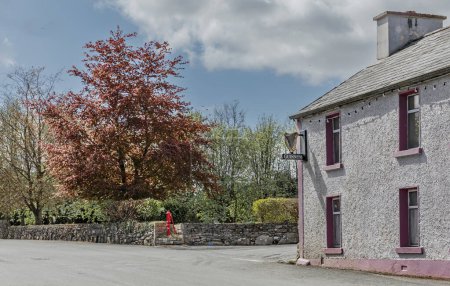 Foto de Condado de Mayo, Irlanda - 24 de abril de 2024 - Cruce de caminos en un pequeño pueblo irlandés con la bomba de agua del pueblo - Imagen libre de derechos