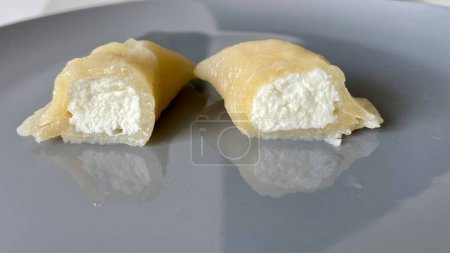 Dumpling con queso cortado por la mitad en un plato gris. Foto de alta calidad