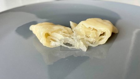 Dumplings con repollo cortado por la mitad en un plato gris. Foto de alta calidad