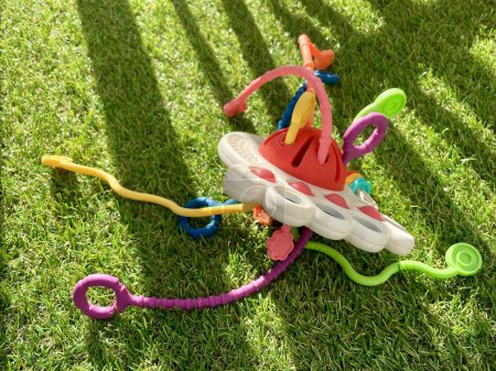 A bright childrens toy lies on artificial grass. High quality photo
