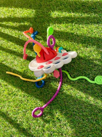 Un juguete brillante para niños se encuentra en césped artificial. Foto de alta calidad