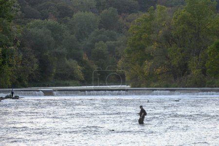 Toronto, ON, Canada - October 10, 2023: Fisherman fishing in the Humber River on an autumn day