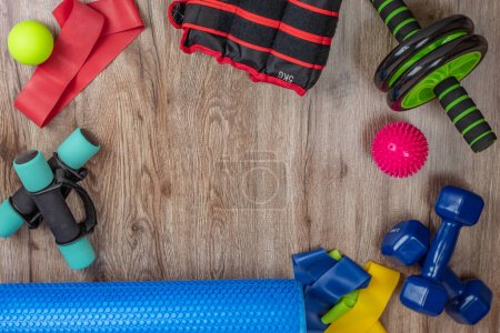 Photo for Set of equipment for fitness and physical education. Dumbbells, leg weights, fitness roller, elastic bands, spiky and smooth acupuncture balls, abs and back roller. Concept of health and longevity. - Royalty Free Image