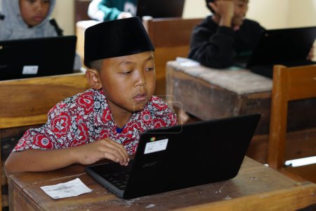 Foto de Editorial. Bawang, Jawa Tengah, Indonesia - October 19 2022. Indonesian elementary school students study online using chrome laptops - Imagen libre de derechos