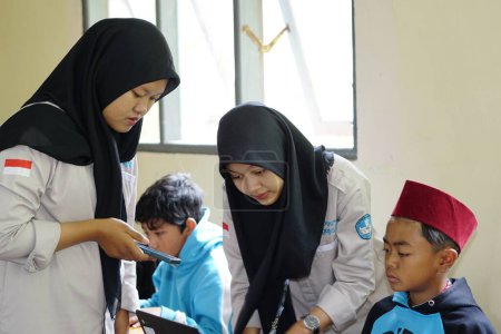 Foto de Editorial. Bawang, Jawa Tengah, Indonesia - October 19 2022. Indonesian elementary school students study online using chrome laptops - Imagen libre de derechos