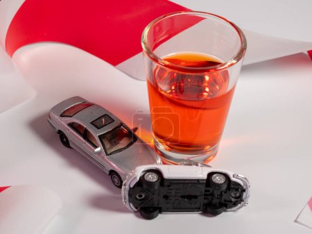 Téléchargez les photos : Mini accident de voiture. Alcool et une voiture jouet sur un fond clair. Avertissement de conduite en état d'ébriété. - en image libre de droit