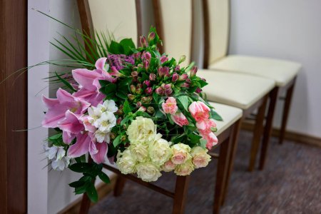Foto de Gran ramo de flores de colores en una silla blanca. Día de la boda. - Imagen libre de derechos