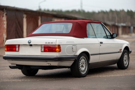 Photo for Riga, Latvia - April 1, 2024: Back view of the white classic BMW E30 car with red roof. - Royalty Free Image