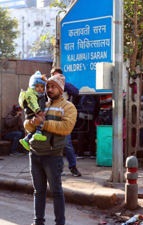 Téléchargez les photos : DELHI INDIA - 02 12 2023 : Portrait d'un jeune Indien posant avec son fils dans un parc de New Delhi - en image libre de droit