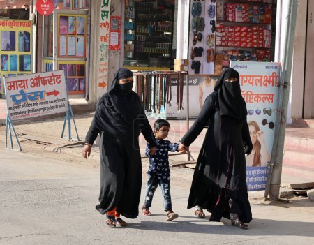 Téléchargez les photos : DELHI INDIA - 02 12 2023 : Des femmes voilées et une veste noire font leurs courses sur le marché. - en image libre de droit