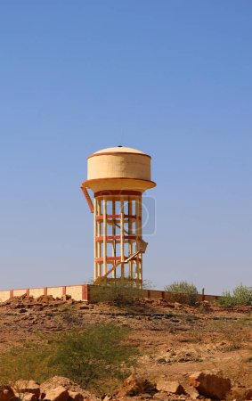 Téléchargez les photos : RURAL RAJASTHAN INDIA - 02 13 2023 : Château-réservoir d'eau peint en jaune pendant la saison sèche - en image libre de droit