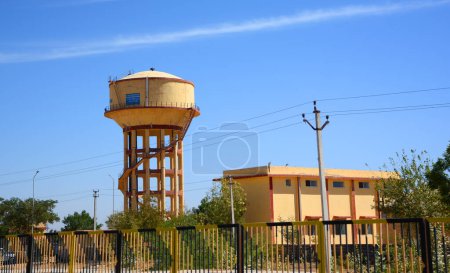 Téléchargez les photos : RURAL RAJASTHAN INDIA - 02 13 2023 : Château-réservoir d'eau peint en jaune pendant la saison sèche - en image libre de droit