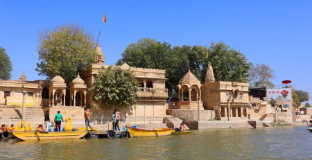 Foto de JAISALMER RAJASTHAN INDIA - 02 13 2023: Lago Gadisar por la mañana. Depósito de agua artificial con templos en Jaisalmer. Rajastán. India - Imagen libre de derechos