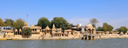 Foto de JAISALMER RAJASTHAN INDIA - 02 13 2023: Lago Gadisar por la mañana. Depósito de agua artificial con templos en Jaisalmer. Rajastán. India - Imagen libre de derechos