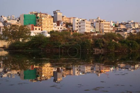 Téléchargez les photos : UDAIPUR RAJASTHAN INDIA - 02 20 2023 : Constructions le long du rivage du lac Pichola. Lac Pichola est un lac artificiel d'eau douce, créé en l'an 1362. - en image libre de droit