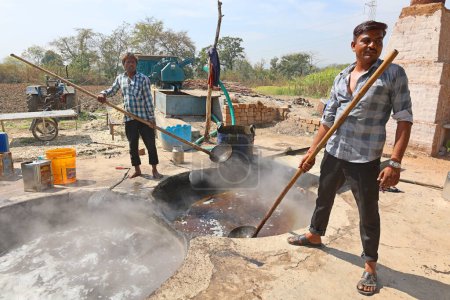 Téléchargez les photos : RURAL RAJASTHAN INDIA - 02 16 2023 : Hommes travaillant dans une usine de canne à sucre bouillante - en image libre de droit