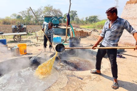 Téléchargez les photos : RURAL RAJASTHAN INDIA - 02 16 2023 : Hommes travaillant dans une usine de canne à sucre bouillante - en image libre de droit