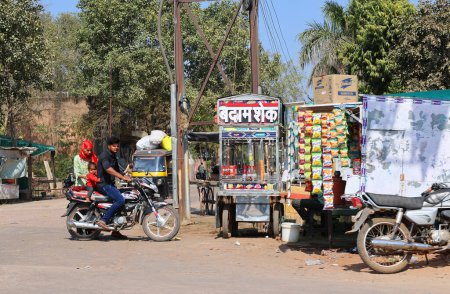 Foto de RURAL RAJASTHAN INDIA - 02 15 2023: Hombre vendiendo bocadillos en el stand de la calle - Imagen libre de derechos