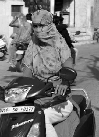 Téléchargez les photos : BUNDI RAJASTHAN INDIA - 02 17 2023 : Un scooter féminin lui couvrait le visage et la tête. - en image libre de droit