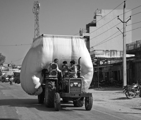 Téléchargez les photos : RURAL RAJASTHAN INDIA - 02 23 2023 : Le tracteur transporte du foin et se déplace sur la route. - en image libre de droit