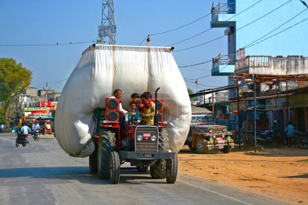 Foto de RURAL RAJASTHAN INDIA - 02 23 2023: Tractor lleva heno y se mueve por carretera. - Imagen libre de derechos