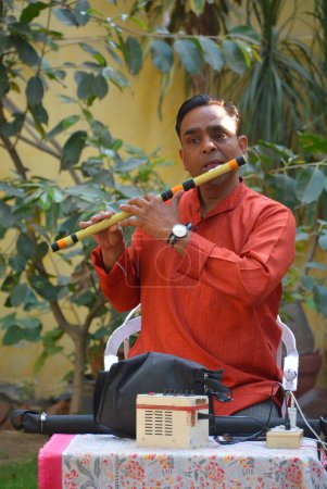 Photo for JAIPUR RAJASTHAN INDIA - 02 28 2023: The flutist plays a national musical instrument. Flute in an elderly man in traditional clothes. - Royalty Free Image