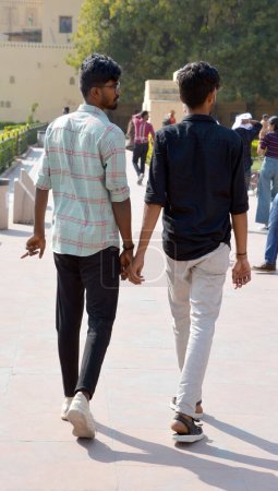 Téléchargez les photos : JAIPUR RAJASTHAN INDIA - 02 28 2023 : Deux jeunes hommes se tiennent la main. Une norme culturelle surprenante prévaut en Inde : les hommes ici aiment se tenir la main. - en image libre de droit