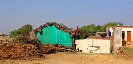 Téléchargez les photos : RURAL RAJASTHAN INDIA - 02 28 2023 : Petite maison de village indienne traditionnelle. Bâtiments colorés de la zone rurale en Inde. - en image libre de droit