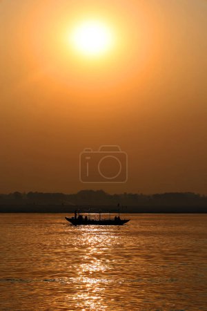 Photo for Boat sihouette at sun rises over the eastern riverbank of the Ganges River near Varanasi India. - Royalty Free Image