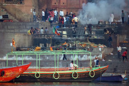 Téléchargez les photos : VARANASI BHOJPUR PURVANCHAL INDIA - 03 05 2023 : Vue de la cérémonie de crémation d'une personne hindoue inconnue à Manikarnika Ghat devant le fleuve Ganges à Varanasi - en image libre de droit