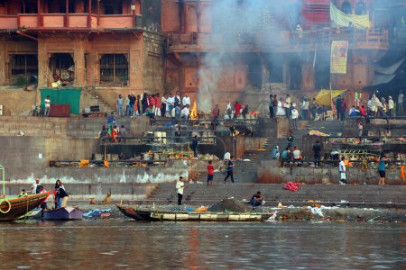 Foto de VARANASI BHOJPUR PURVANCHAL INDIA - 03 05 2023: Vista de la ceremonia de la cremación de una persona hindú desconocida en Manikarnika Ghat frente al río Ganges en Varanasi - Imagen libre de derechos