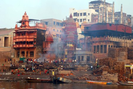 Foto de VARANASI BHOJPUR PURVANCHAL INDIA - 03 05 2023: Vista de la ceremonia de la cremación de una persona hindú desconocida en Manikarnika Ghat frente al río Ganges en Varanasi - Imagen libre de derechos