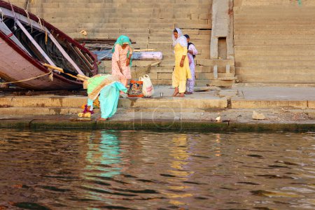 Téléchargez les photos : VARANASI BHOJPUR PURVANCHAL INDIA - 03 05 2023 : Les hindous prennent un bain rituel dans la rivière Ganga dans la ville sainte de Varanasi, en Inde. Le bain rituel sacré se tient tous les jours. - en image libre de droit