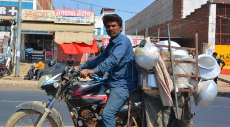 Foto de AMBER RAJASTHAN INDIA - 02 27 2023: Un hombre no identificado conduce una motocicleta con mercancías en una carretera - Imagen libre de derechos