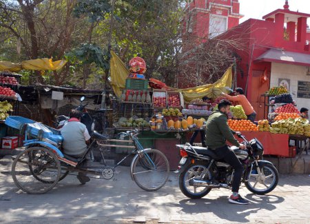 Téléchargez les photos : BIKANER RAJASTHAN INDIA - 02 16 2023 : Des hommes non identifiés conduisent une moto avec des marchandises sur une route - en image libre de droit