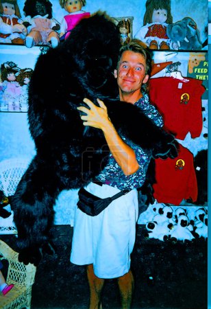 Foto de ATLANTIC CITY USA - 08 12 1989: El hombre tiene un gran gorila en la mano en una juguetería. - Imagen libre de derechos