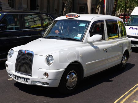 Téléchargez les photos : LONDRES ROYAUME-UNI - 06 19 2023 : Typique taxi londonien noir dans les rues de la ville. Traditionnellement taxis sont tous noirs à Londres, mais maintenant produites en différentes couleurs. - en image libre de droit